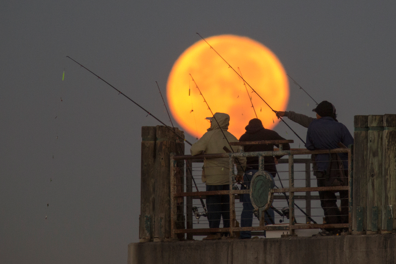 La superluna y unos pescadores en Redondo beach, California. Imagen: David McNew / Getty